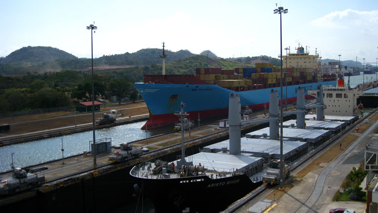 Massive ships move through the Canal locks at Mira Flores. The blue ship here paid $297,000 dollars toll.